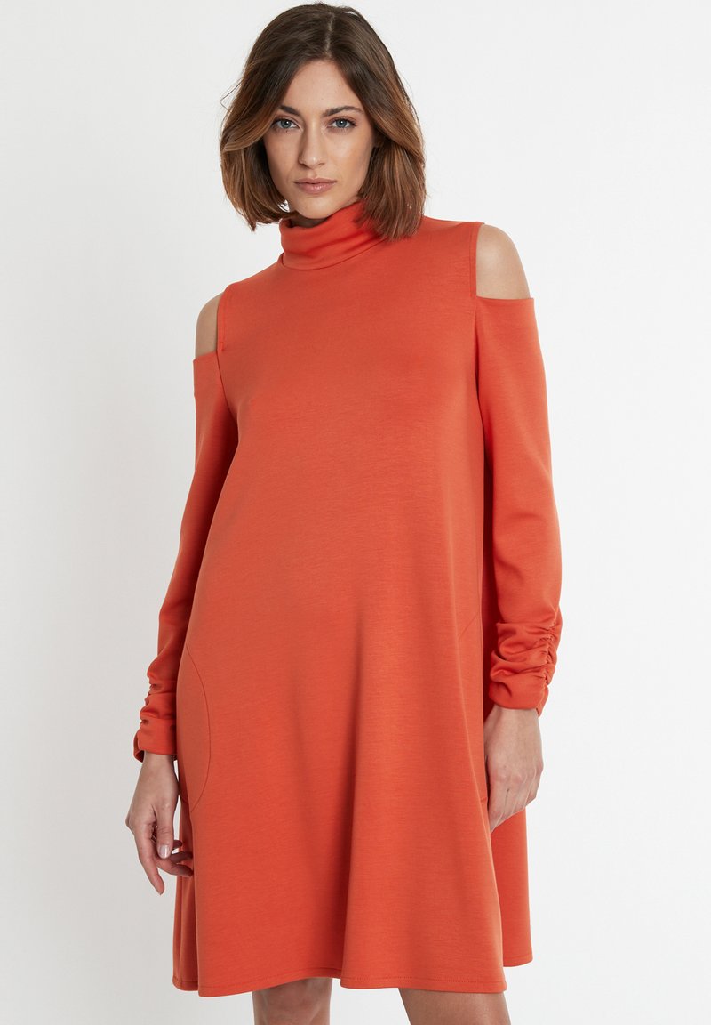 Orangenes Langarmkleid mit einem Stehkragen, ausgeschnittenen Schultern und gerafften Manschetten, aus einem glatten Stoff gefertigt.