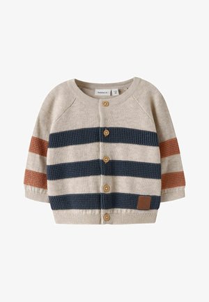 Beige gebreid babyvest met marineblauwe en bruine horizontale strepen, knopen aan de voorkant en een ronde hals.