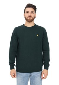 Maglione lavorato a maglia verde scuro con scollatura rotonda, maniche lunghe e un piccolo logo giallo sul petto. Miscelato di cotone, texture morbida.