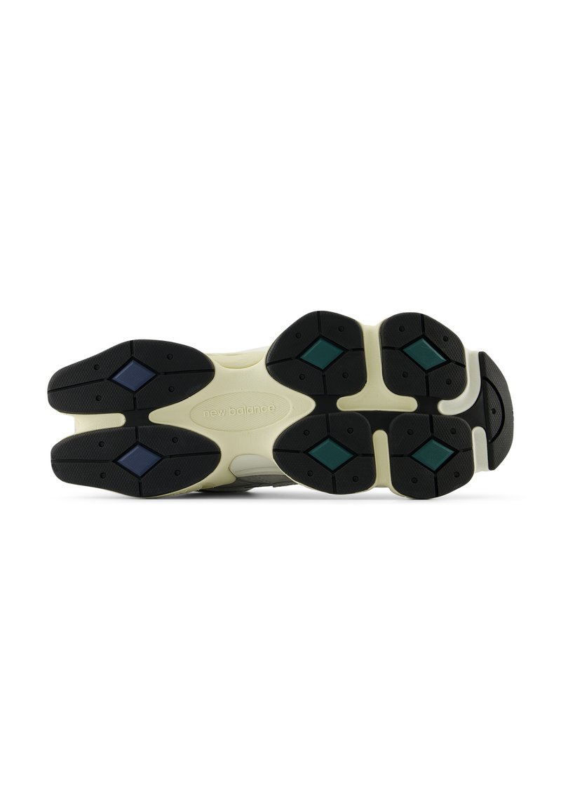 Black rubber outsole with multi-colored diamond-shaped accents in teal and blue. Cream-colored midsole, featuring a textured design.