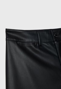 Jupe noire en similicuir avec passants de ceinture, une poche latérale avec rivets et une fermeture par bouton marqué à la taille.