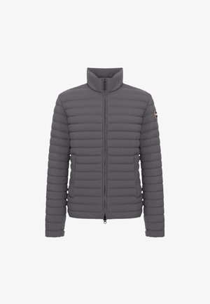 Grå pufferjakke med høj krave, lynlås lukning og ribbet tekstur. Har et emblem på venstre ærme og sidelommer.