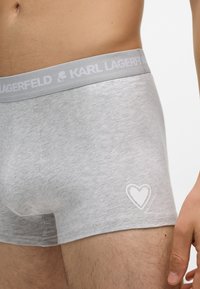 Szürke pamut boxer alsónadrág világos rugalmas derékpánttal, amelyen a "KARL LAGERFELD" logó és egy fehér szívmintázat található az elején.