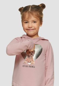Lichtroze hoodie met lange mouwen en een zilveren hartprint met een hond, en de tekst "Laten we vrienden zijn" onder de afbeelding. Zachte stof en standaard pasvorm.