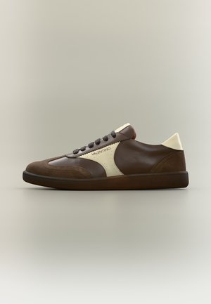 Baskets basses en cuir marron avec accents crème, laçage à l'avant et marquage Valentino sur le panneau latéral et la semelle.