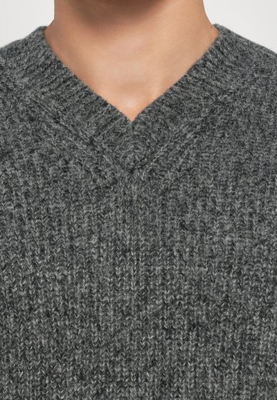 Gray knitted sweater with a V-neck design. Features a textured pattern with vertical ribbing and a soft, thick fabric.