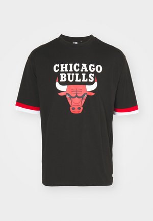 Černé tričko s krátkým rukávem s výrazným červeným logem Chicago Bulls a bílým textem. Má červenobílé pruhované detaily na rukávech.