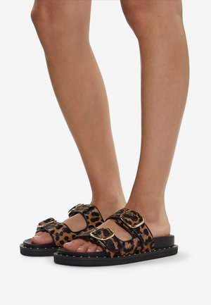 Leopard print slip-on sandals with two adjustable straps, black rubber sole, and gold-tone hardware detailing.