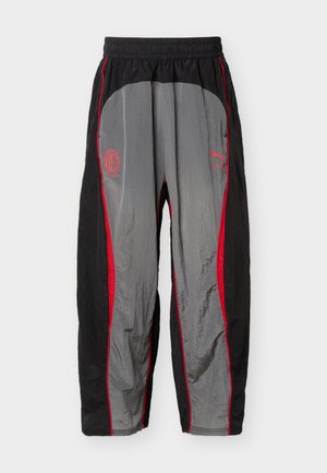 Černé a šedé sportovní kalhoty s červeným lemem, elastickým pasem, logem AC Milán na levém stehně a logem Puma na pravém stehně.