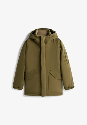 Oliwkowa ocieplana parka z kapturem, zapięciem na zatrzaski z przodu, dużymi bocznymi kieszeniami i zamykaną kieszenią na rękawie. Gładka, matowa tekstura.