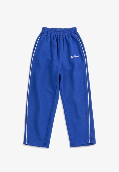 Pantalones de chándal de forro polar azul con franjas laterales blancas, cintura elástica, bolsillos laterales y logotipo de "Bobo Choses" en el muslo izquierdo.