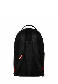 Zaino nero con spallacci imbottiti e ventilati, pannello posteriore testurizzato e dettagli rossi. Ha una maniglia superiore e una chiusura con cerniera.
