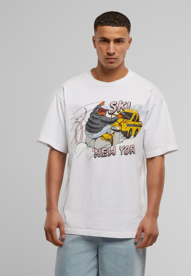 T-shirt en coton blanc avec un design graphique "SKI NEW YORK", représentant un skieur et un taxi jaune. Manches courtes, coupe décontractée.