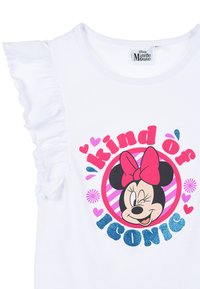 Camiseta de algodón blanca con mangas acampanadas, un gráfico de Minnie Mouse con corazones rosas y el texto "un poco ICONIC" en purpurina azul.