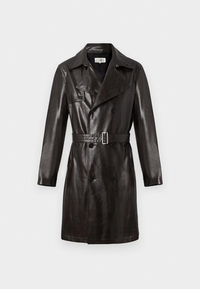 Melnā ādas divpusējā trenčmēte ar jostu viduklī, norādītu apkakli un garām piedurknēm. Gluda tekstūra, minimāls aparatūras detaļu klāsts.