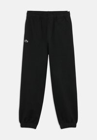 Schwarze Sweatpants mit elastischem Bund, schmal zulaufenden Knöcheln, Seitentaschen und einem kleinen gestickten Logo in Weiß und bunten Akzenten.