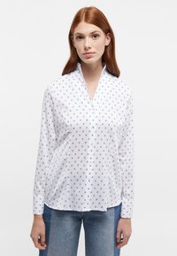 White button-up shirt featuring a subtle blue circular pattern, long sleeves, and a pointed collar with a smooth texture.