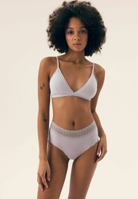 Zestaw bielizny w jasnym lawendowym kolorze, składający się z trójkątnego biustonosza na cienkich ramiączkach oraz majtek o wysokim stanie ozdobionych koronkowym wykończeniem. Gładka textura materiału.