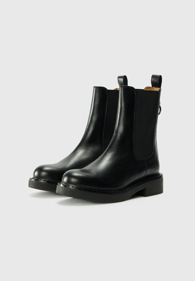 Schwarze Leder-Stiefeletten mit elastischen seitlichen Einsätzen, Zuglaschen und einer massiven Gummisohle mit gesticktem Besatz.