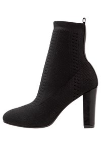 Czarne botki za kostkę z dzianinową cholewką, z teksturowanymi detalami i wysokim obcasem w szpilce. Elegancki design z okrągłym noskiem.