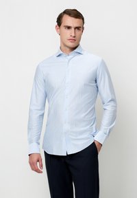 Lichtblauw gestreept overhemd met lange mouwen van gladde stof, voorzien van een button-down kraag en een getailleerd ontwerp. Tailored fit met een afgeronde zoom.