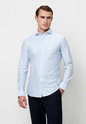 Camicia a maniche lunghe a righe azzurro chiaro, realizzata in tessuto liscio, con colletto button-down e design aderente. Vestibilità sartoriale con orlo curvo.