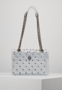 Borsa a tracolla in plastica trasparente con design trapuntato, borchie argentate e tracolla a catena. Presenta una forma rettangolare e chiusura a pattina.