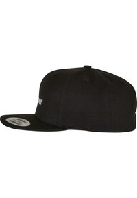 Black snapback cap with a flat brim, made of textured fabric, featuring a white logo detail on the front. Smooth finish and fitted design.