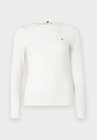 Λευκή ριγέ μπλούζα με μακρύ μανίκι, στρογγυλή λαιμόκοψη και μικρό λογότυπο στο στήθος. Το ύφασμα φαίνεται μαλακό και με υφή.