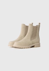 Beige chelsea støvler med en glat ruskindsfinish, elastiske sidelapper og en robust gummisål. Har en løkke for nem påtagning.