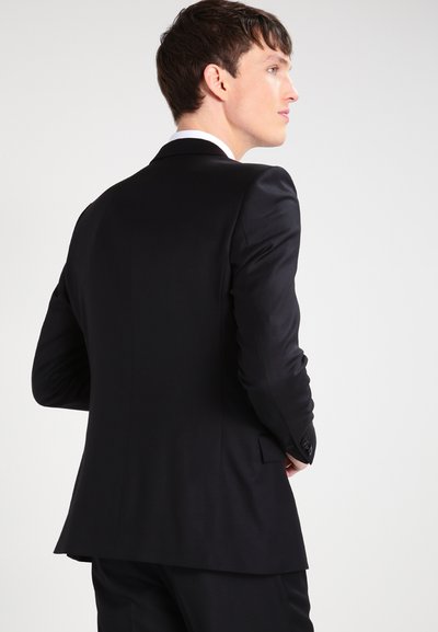 Op maat gemaakt zwart suitjacket met een soepele textuur, slim fit en een enkele split aan de achterkant. Inclusief traditionele revers en knoopaccenten.