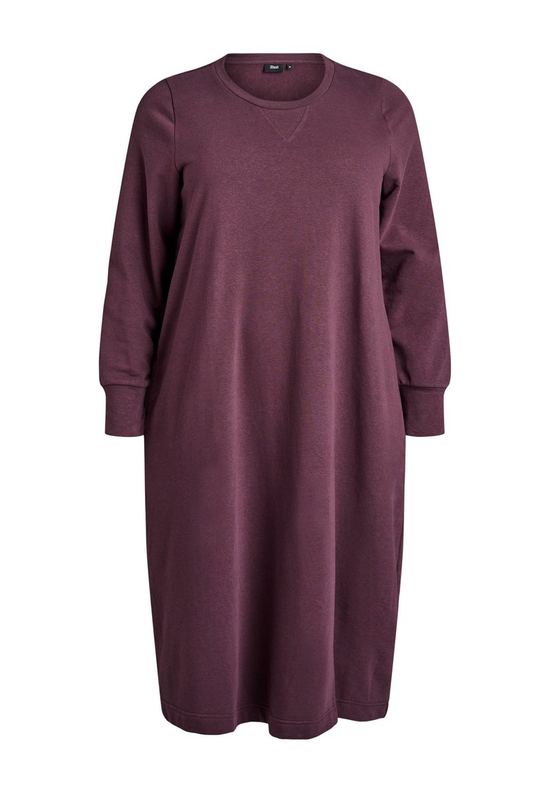 Robe sweat bordeaux en tissu doux. Elle présente des manches longues, un col rond et une silhouette droite avec une coupe mi-longue.