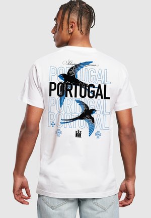 T-shirt in cotone bianco con grafica di un uccello blu e nero e il testo "PORTOGALLO" ripetuto in un carattere audace sul retro.