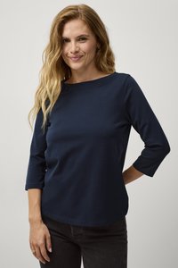 Camisetta blu navy a maniche 3/4 realizzata in tessuto morbido con scollatura rotonda. Ha un design semplice e aderente con orlo curvo.