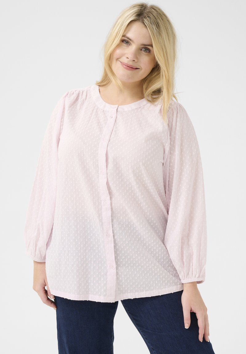 Camicia button-up rosa chiaro con maniche a palloncino, punti in rilievo e scollatura tonda. Realizzata in un tessuto trasparente, presenta un orlo curvo.