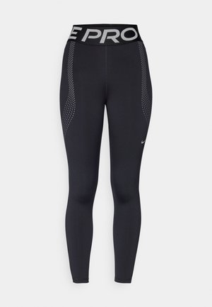 Leggings sportivi neri con una vestibilità aderente, caratterizzati da una fascia in vita ampia con la scritta "PRO" in argento e dettagli a pois sui lati.