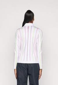 White long-sleeve top featuring vertical stripes in pink, green, and purple. Includes a collar and a small logo on the upper back.