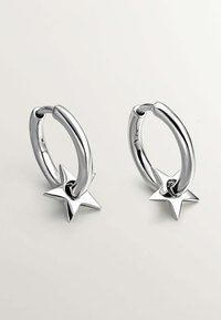Los pendientes de aro de plata cuentan con un acabado pulido y detalles en forma de estrella, combinando un diseño circular suave con distintivos acentos de estrella.