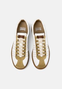 Sneakers bianche con dettagli in suede beige, presenta una punta rotonda, design con lacci e un motivo cucito ai lati. Suola in gomma marrone.