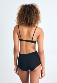 Black lingerie set featuring a bralette with adjustable straps and a clasp, paired with high-waisted bottoms. Smooth texture, minimalist design.