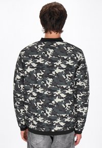 Camouflage-print jack in grijstinten en beige, met een zwarte kraag en manchetten, een gladde stofstructuur en een ontspannen pasvorm.