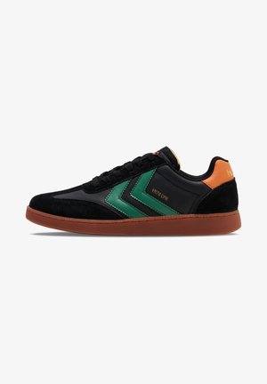 Sorte sneakers med grønne chevron-detaljer, lavet af suede og syntetiske materialer, orange hælflap og brun gummisål. Snøredesign med logodetalje.