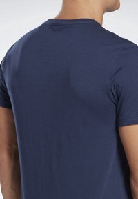 Niebieska koszulka z miękkiej bawełny, z okrągłym dekoltem i krótkimi rękawami, o prostym wzorze i gładkiej fakturze.