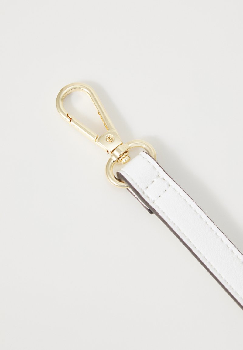 Sangle en cuir blanc avec quincaillerie en métal doré, comportant un crochet à bouton-pression et une texture lisse, des coutures détaillées, et un attachement en anneau circulaire.