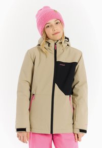 Beige winterjack met een zwart ontwerpaccent, roze ritsen en een afneembare capuchon, gedragen met een roze gebreide beanie. Zachte textuur.