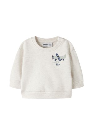 Chemise bébé beige à manches longues avec un avion bleu brodé et les mots "Let's fly" sur la poitrine.