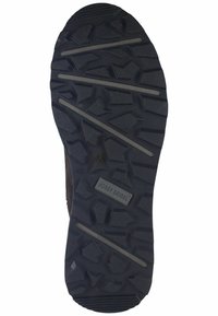 Suela de goma negra con un patrón de tread resistente, que presenta clavos gruesos y ranuras integradas para tracción. El logo de la marca es visible.