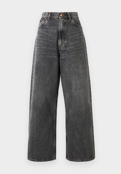 Visokotrajne široke kavbojke v zbledeli črni denimu s sprednjimi žepi, zankami za pas in zlato rjavo zaponko.