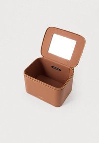 Brun opbevaringsboks med lynlås lavet af tekstureret materiale, med spejlet låg og en sort logomærkat indeni.