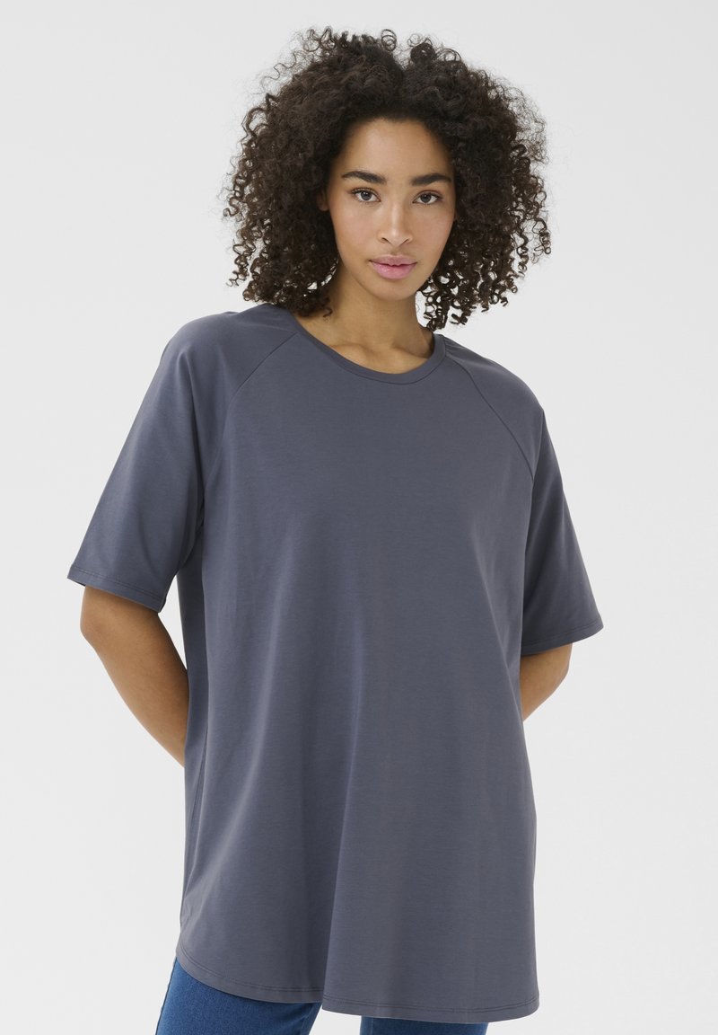 T-shirt grigio oversize con maniche raglan corte, scollo rotondo e texture liscia. Progettato per una vestibilità rilassata, arriva sotto i fianchi.